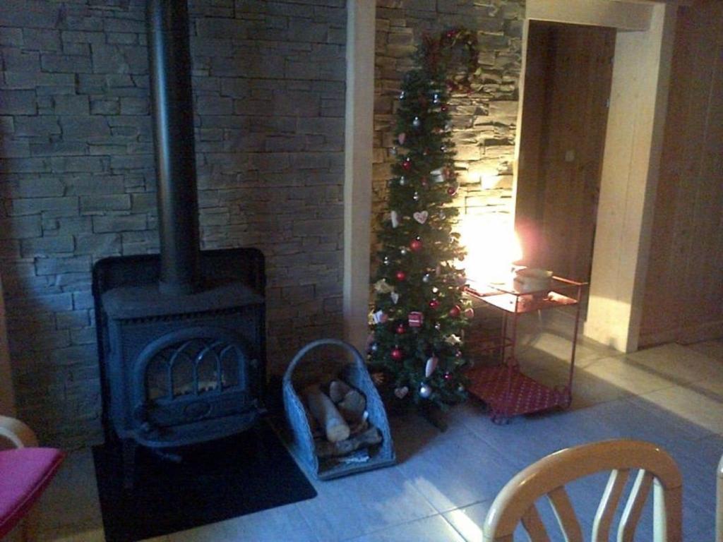 a christmas tree in a living room with a fireplace at Nice sea view apartment with pool in Valfréjus