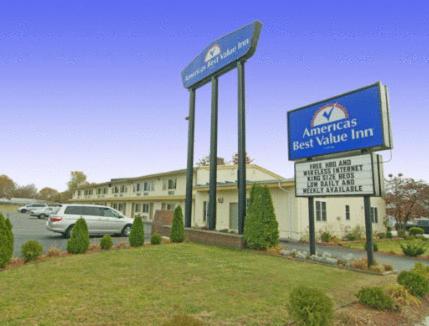 a sign for an american best value inn next to a building at Rumford Motor Inn in Rumford