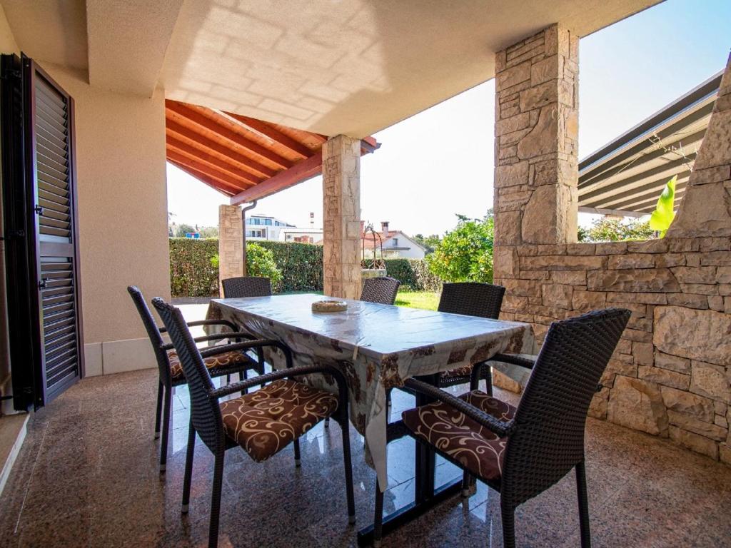 a dining table and chairs on a patio at Modern apartment near the beach in Istria in Vintijan