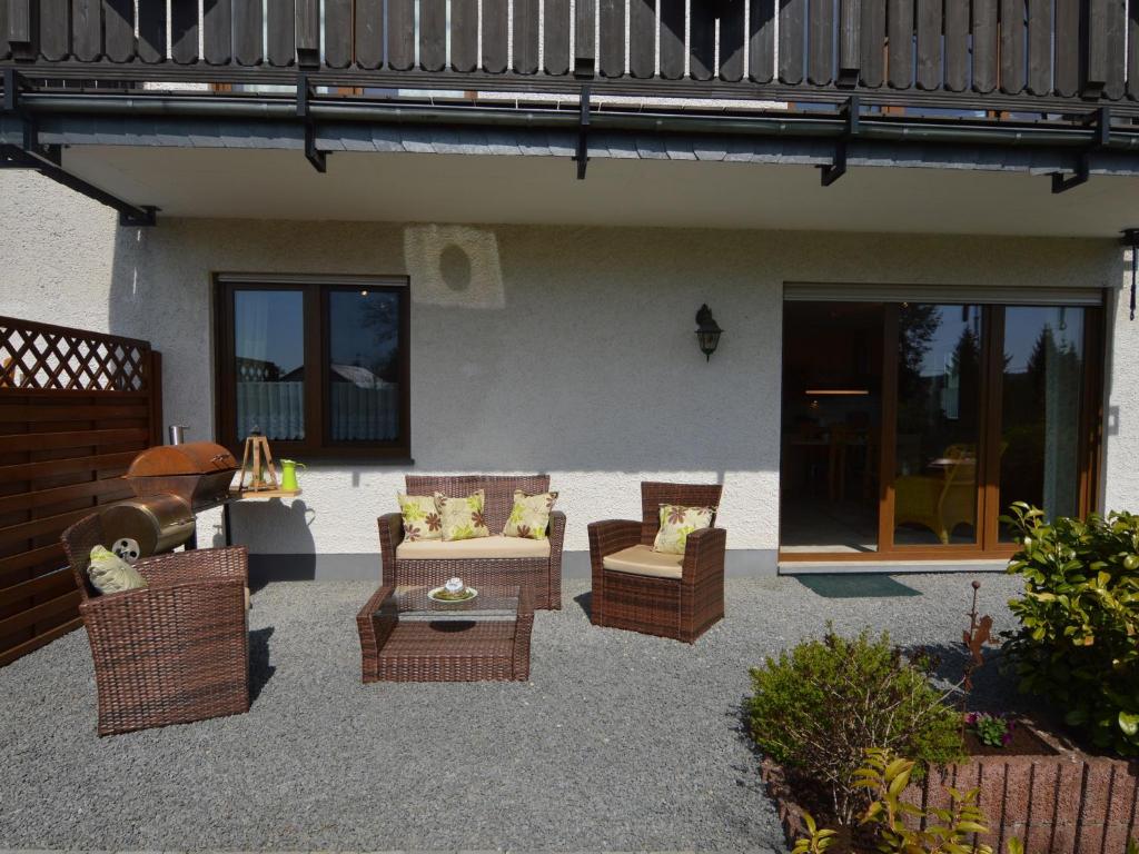 a patio with wicker chairs and a table at Cushy Apartment in Nohn with Terrace Garden BBQ in Nohn