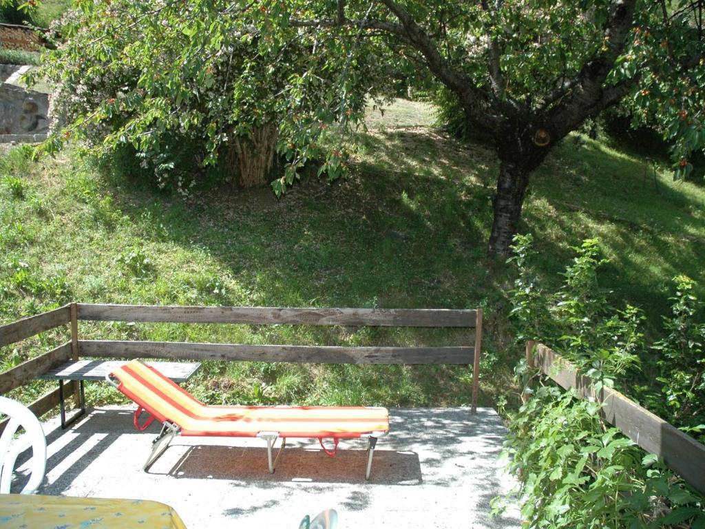 a bench with an orange chair and a table at Chalet in M rel with Terrace Parking Garden Furniture in Mörel