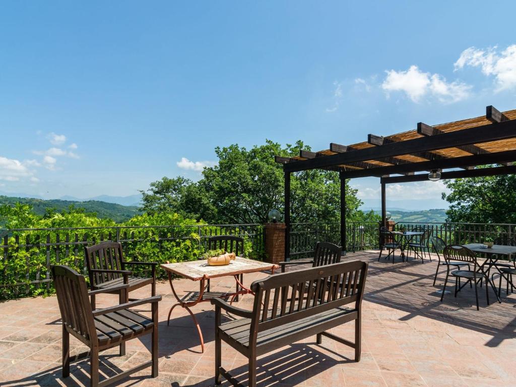 patio ze stołami i krzesłami oraz stołem z widokiem w obiekcie Farmhouse in Umbria with Pool & Views w mieście Biscina