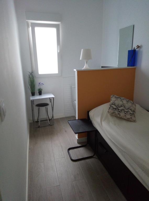 Schlafzimmer mit einem Bett, einem Tisch und einem Fenster in der Unterkunft Alquilo Habitación individual con aseo privado solo Chicas, only girls in Valencia