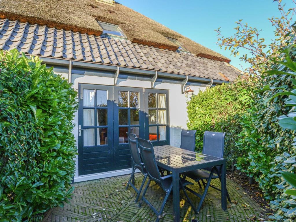 a table and chairs in front of a house at Charming Holiday Home in Texel in Oost