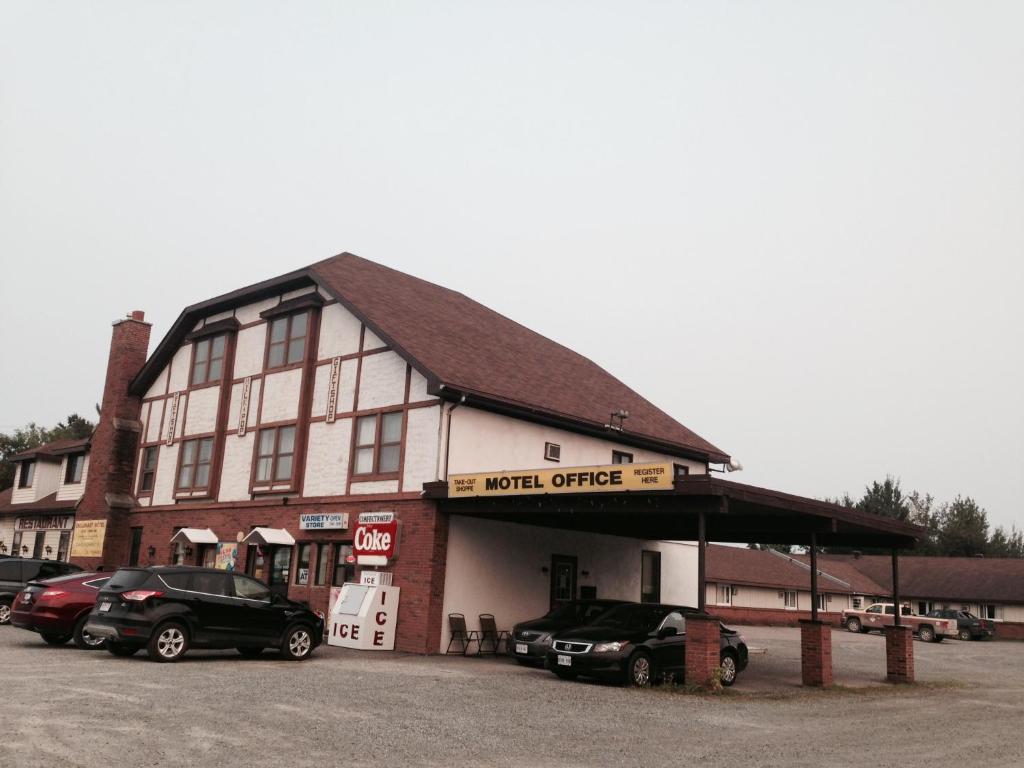 um grande edifício com carros estacionados em frente em Englehart Motel em Englehart