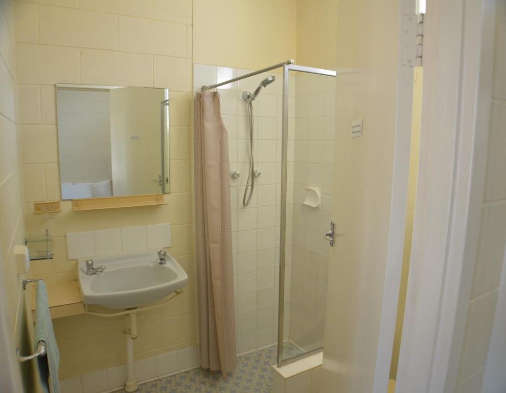 
a bathroom with a shower, sink, and toilet at Glossop Motel in Winkie
