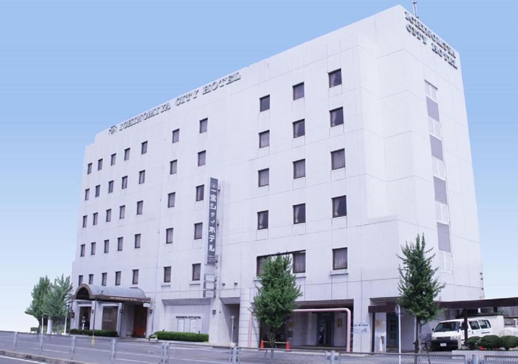 a white building on the corner of a street at Ichinomiya City Hotel in Ichinomiya