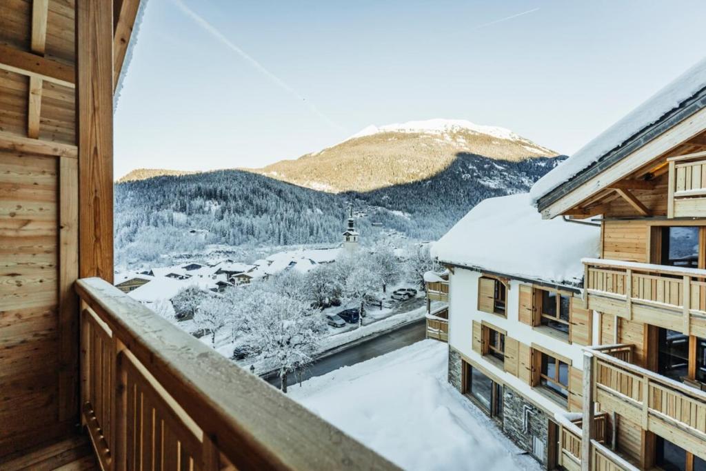 uma vista da varanda de um hotel na neve em Horizon Furnished flat em Les Houches