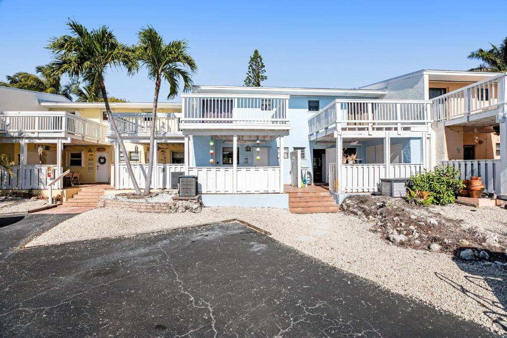 Una gran casa blanca con palmeras y un camino de entrada en Kawama Yacht Club A4, en Cayo Largo