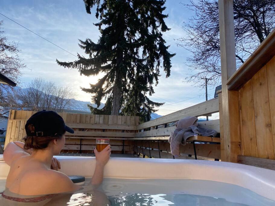 a woman in a hot tub with a drink at Knotty Pine Lodge in Golden