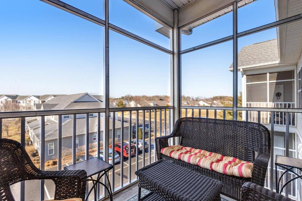 a balcony with two chairs and a table at Villas at Bay Crossing - 34670 Villa Circle Unit #2304 in Lewes