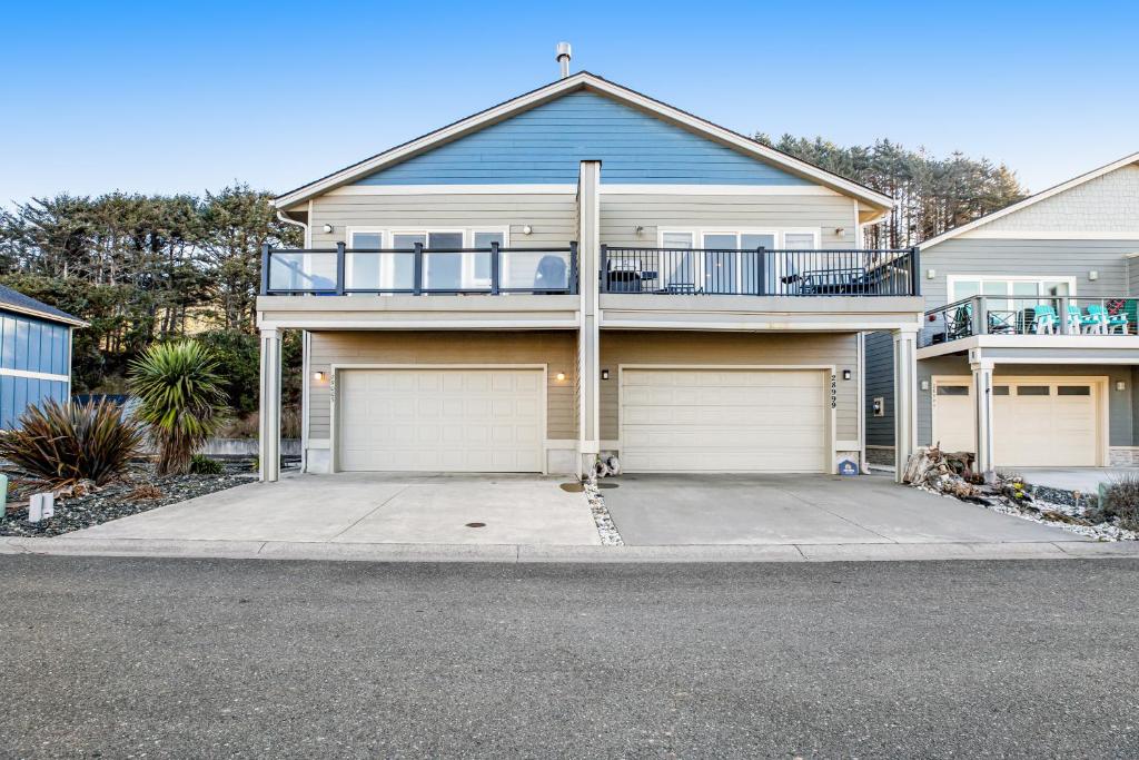 a large house with two garage doors on a street at Ebb & Flow in Gold Beach