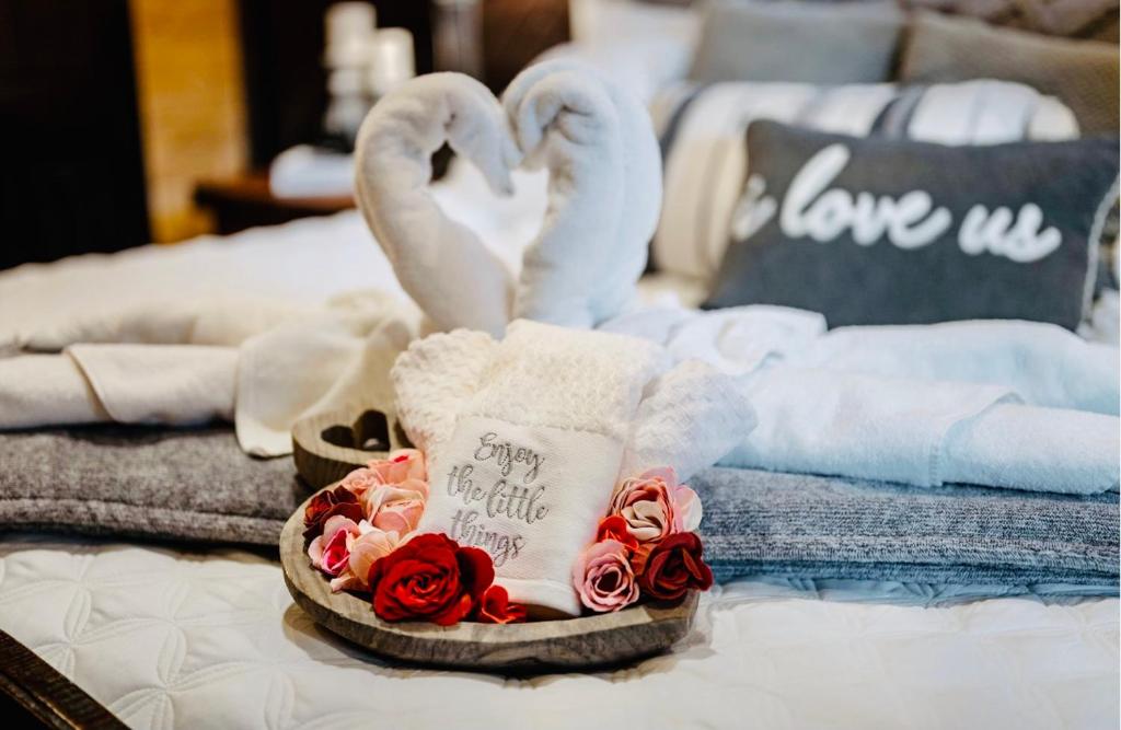 a bed with towels and roses and swan towels at Knotty and Nice Luxury Cabin in Broken Bow