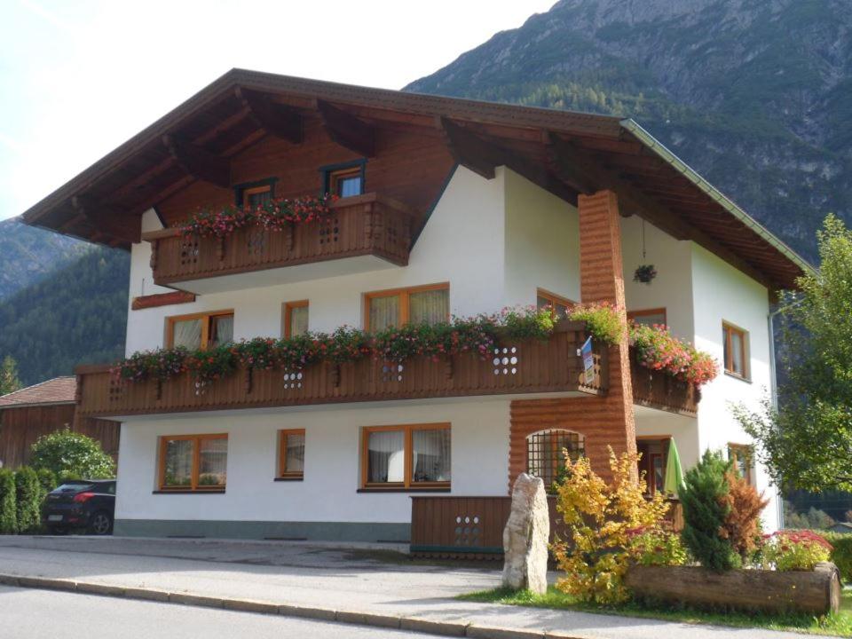 ein Gebäude mit einem Balkon mit Blumen darauf in der Unterkunft Haus Sonnenschein in Holzgau