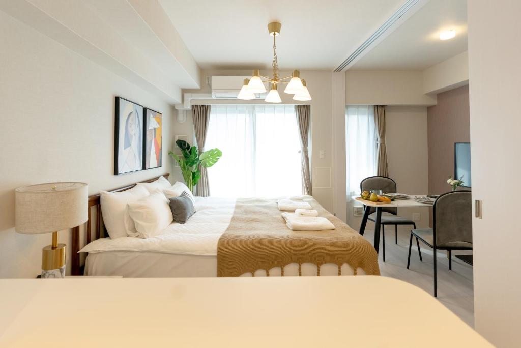 ein Hotelzimmer mit einem Bett, einem Schreibtisch und einem Zimmer in der Unterkunft 谷町君 HOTEL 日本橋47 in Osaka