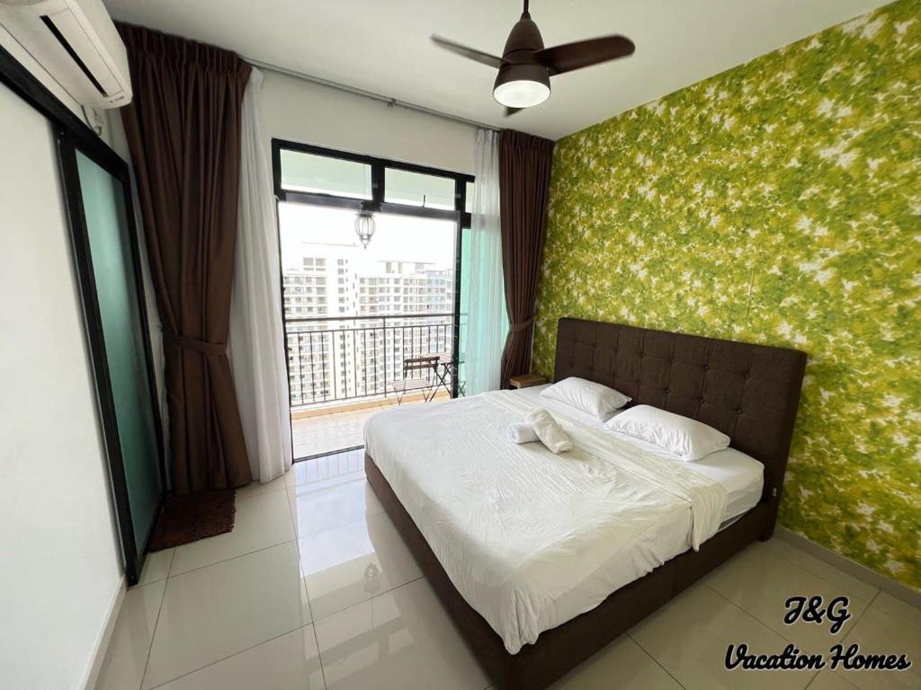1 dormitorio con 1 cama con pared verde en The Garden By J&G Vacation Homes en Skudai