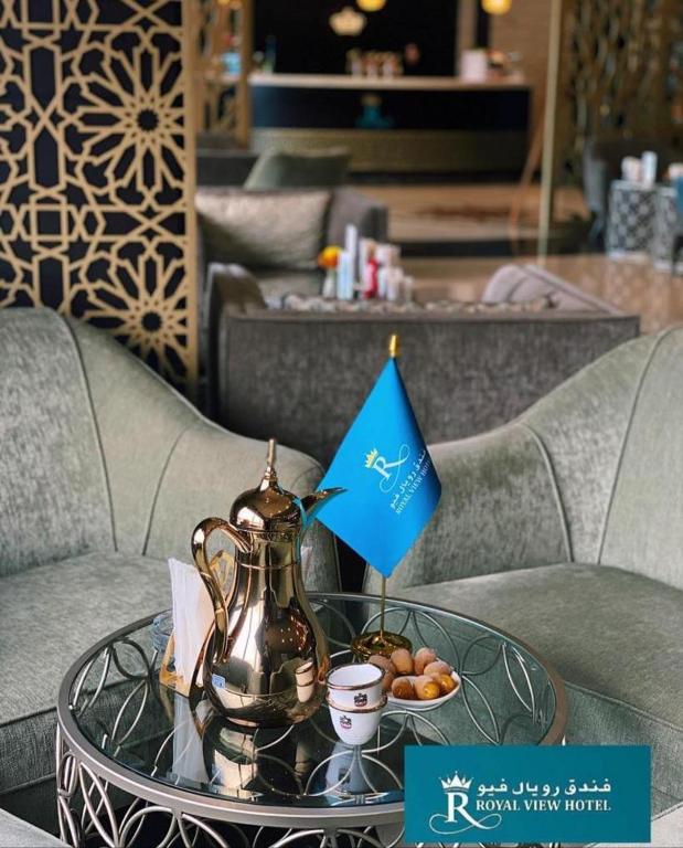 a table with a tea kettle and a cup of coffee at Royal View Hotel in Ras al Khaimah
