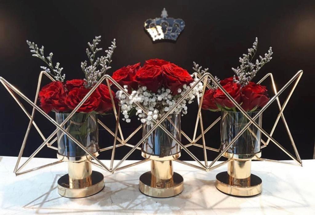 two vases filled with red roses on a table at Royal View Hotel in Ras al Khaimah