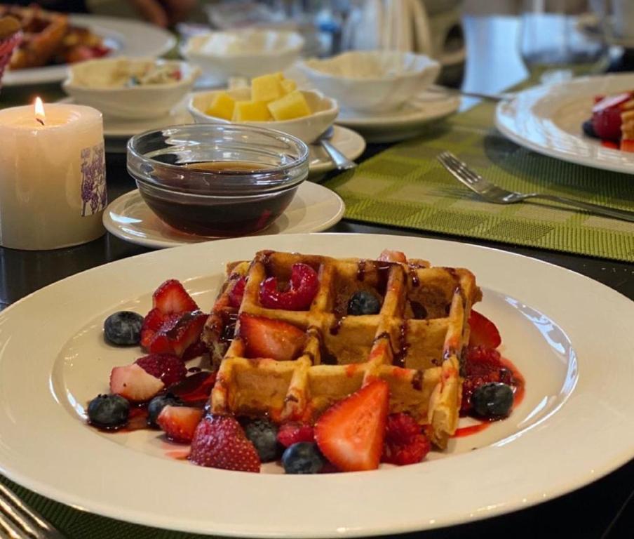 a table with waffles and fruit on a plate at Royal View Hotel in Ras al Khaimah