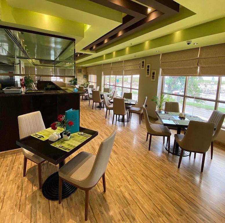 a dining room with tables and chairs and a kitchen at Royal View Hotel in Ras al Khaimah