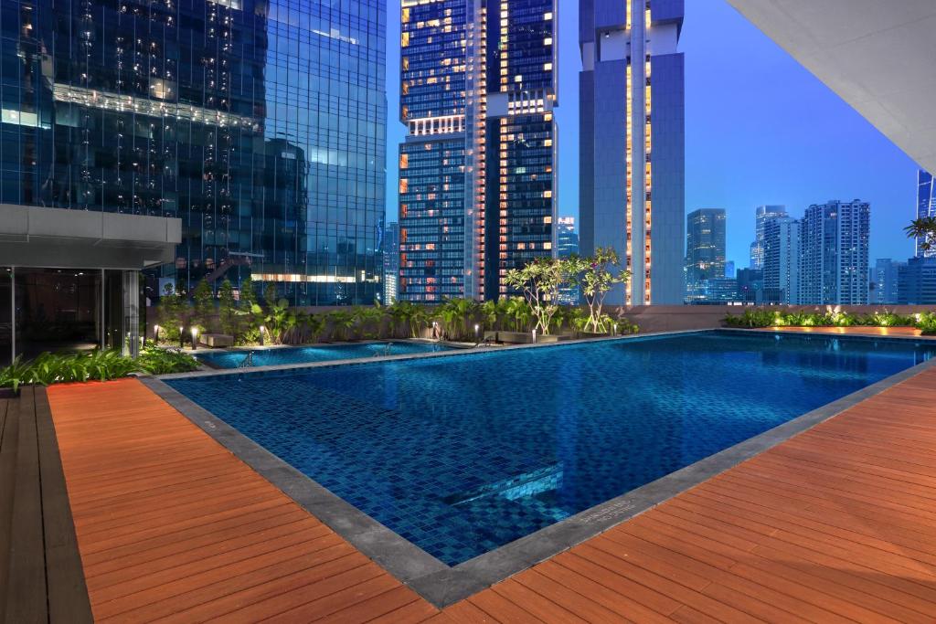 una piscina con vistas al perfil urbano por la noche en Citadines Sudirman Jakarta en Yakarta