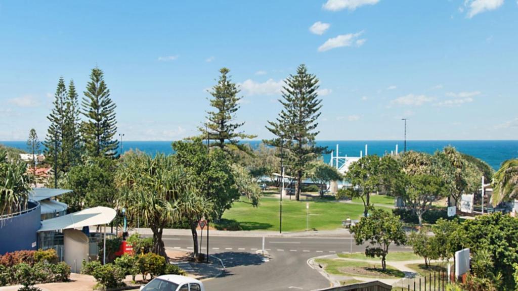 a parking lot with trees and the ocean in the background at Unit 2 'fair Haven' Kings Beach in Caloundra