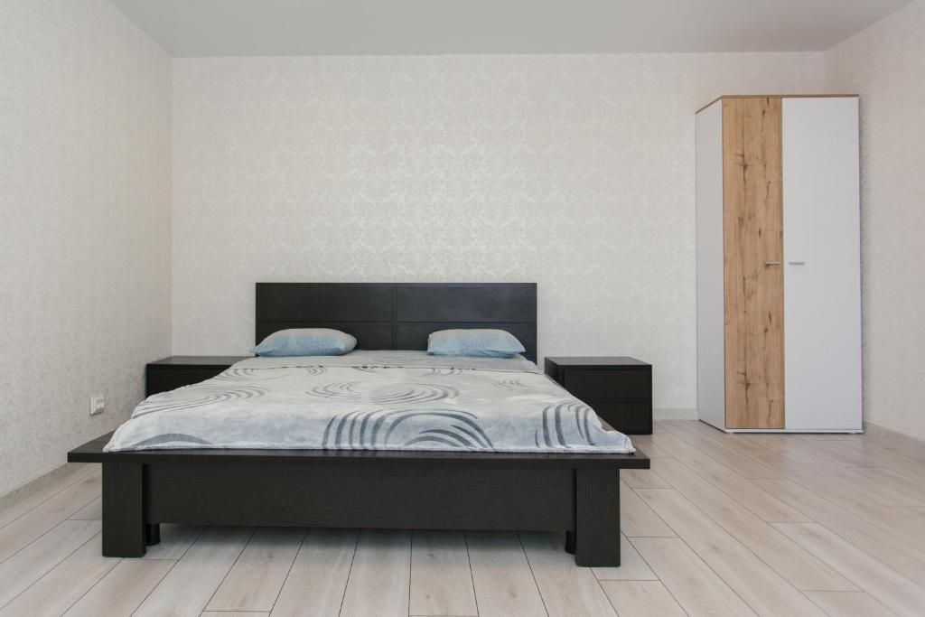 una camera con letto e pavimento in legno di Квартира ЛАВИНА Room a Sumy