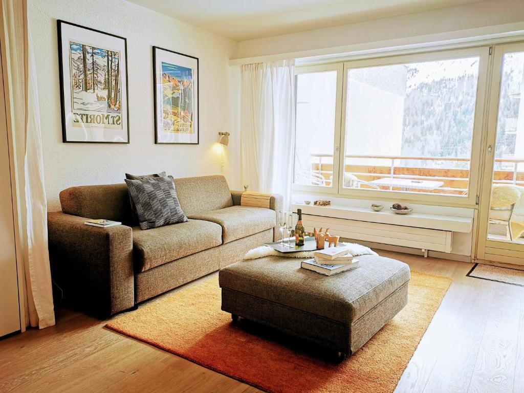 een woonkamer met een bank en een stoel bij Sankt Moritz Spirit Piz San Gian 14 in St. Moritz
