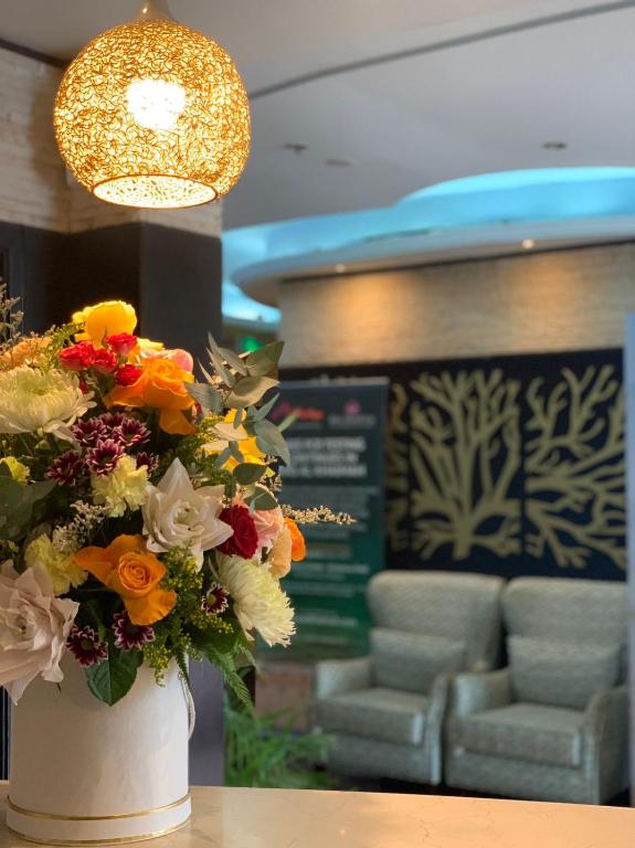 a white vase filled with flowers sitting on a table at Royal View Hotel in Ras al Khaimah