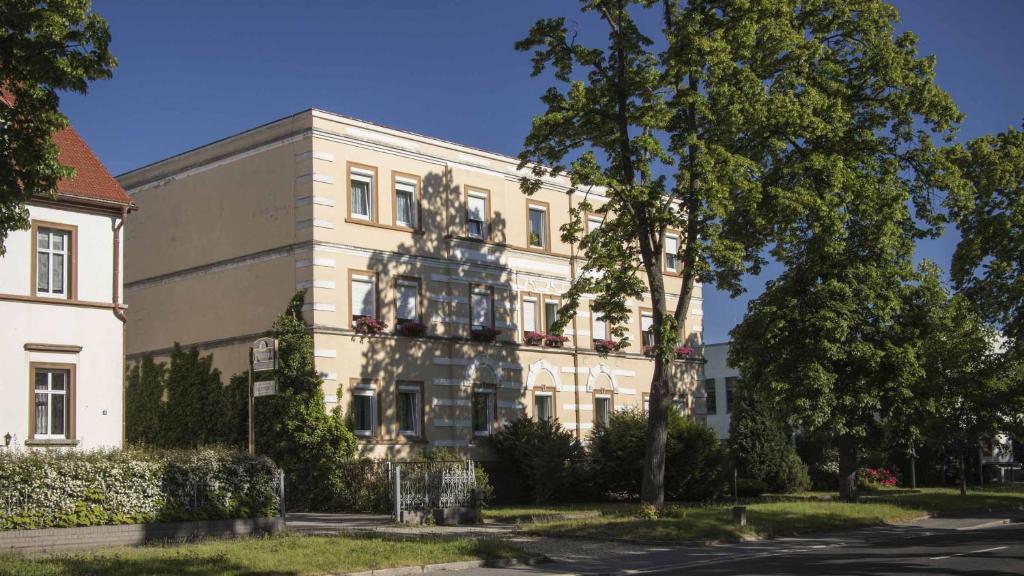 un edificio bianco con un albero di fronte di Bürgerhaus Niesky a Niesky