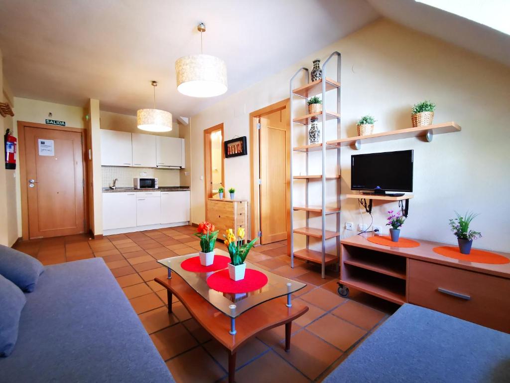 ein Wohnzimmer mit einem Tisch und einer Küche in der Unterkunft IMEDA apartamentos ARTTYCO con parking in Sierra Nevada