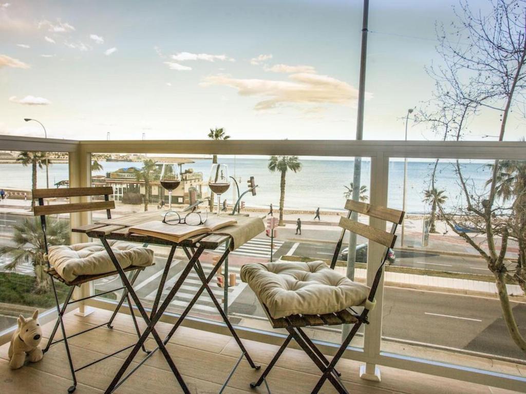 a balcony with a table and chairs and a view of the beach at Holidays2Malaga Mendoza Terrace & Sea View in Málaga