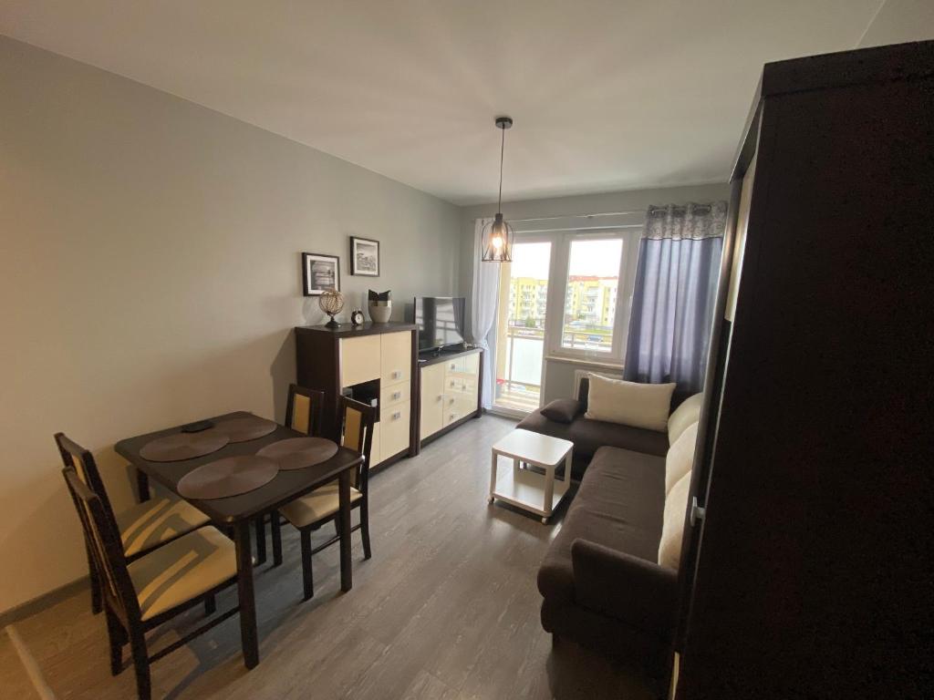 uma sala de estar com uma mesa e um sofá e uma sala de jantar em Apartament Gorzów em Gorzów Wielkopolski