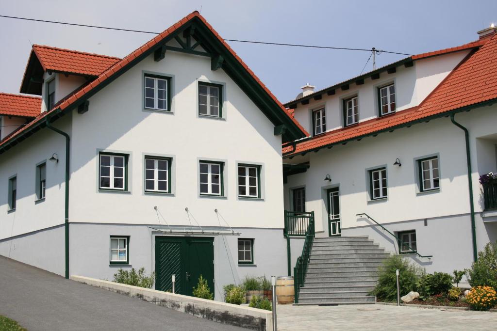 a white building with a green door and stairs at Ferienwohnung Weingut Rennhofer in Eisenberg an der Pinka