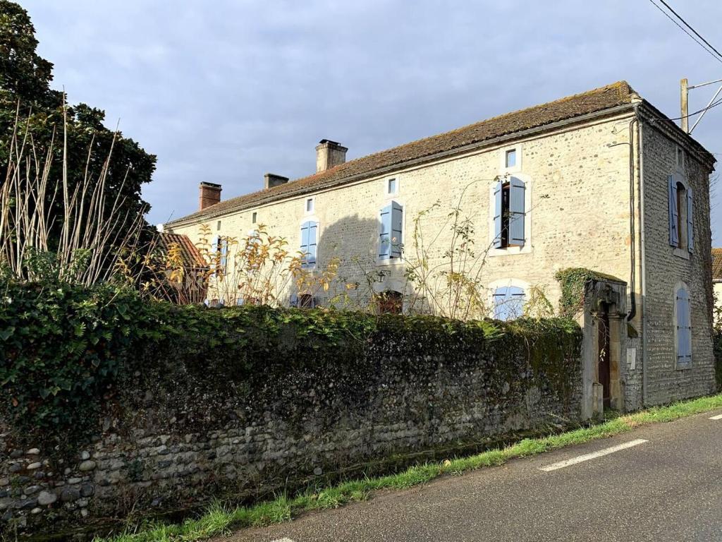 una vieja casa de ladrillo al lado de una calle en Inviting 5-Bed House heated pool Maubourguet, en Maubourguet