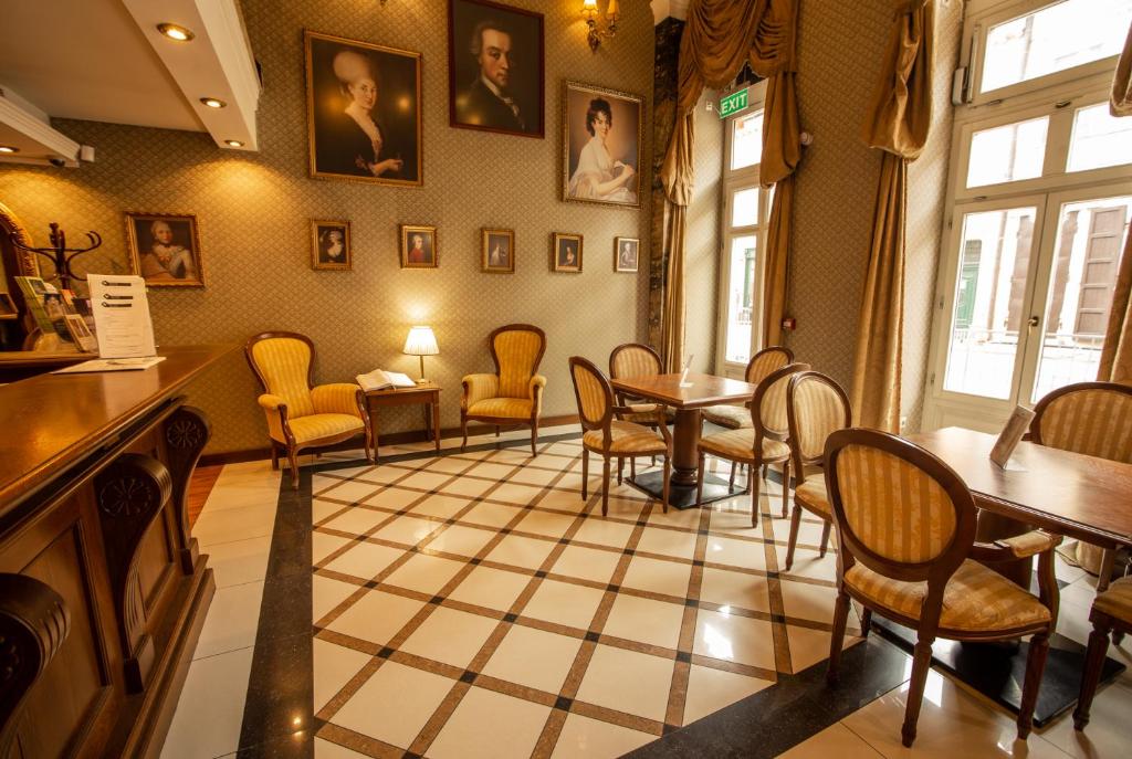 ein Wartezimmer mit Stühlen und Tischen in einem Restaurant in der Unterkunft Mozart Hotel in Szeged