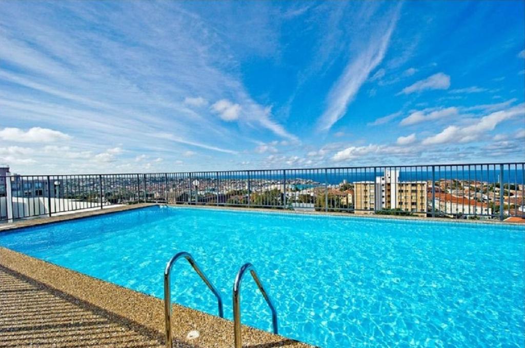 una gran piscina en la parte superior de un edificio con un puente en HolidayRento Bondi Beach Ocean View Rooftop Pool en Sídney