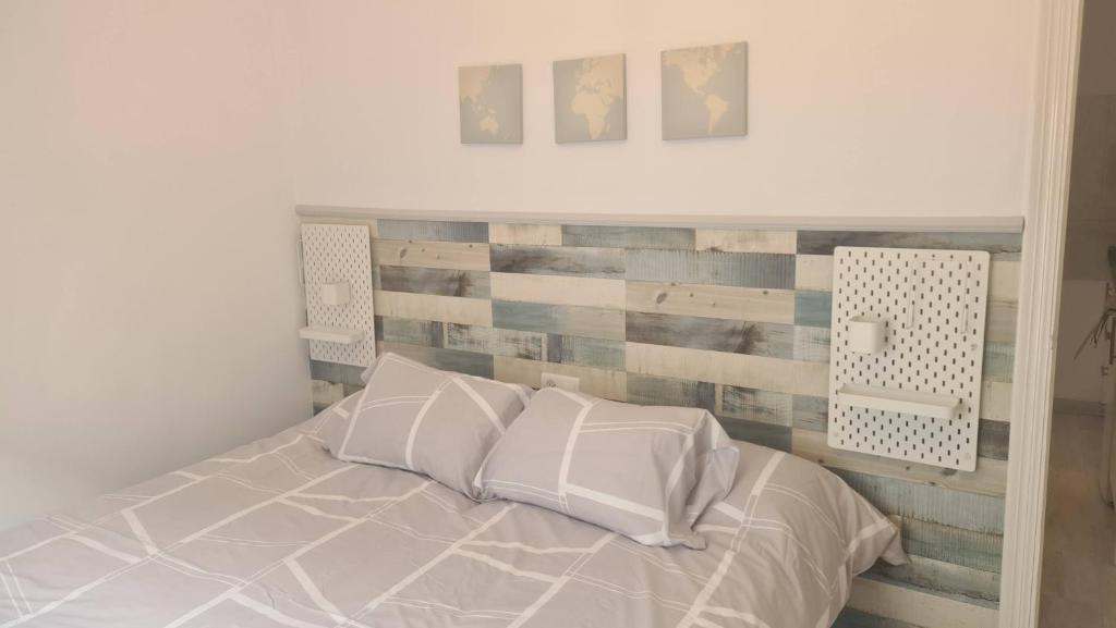 een slaapkamer met een bed met een houten accentwand bij Apartamentos El Barrio in Nerja