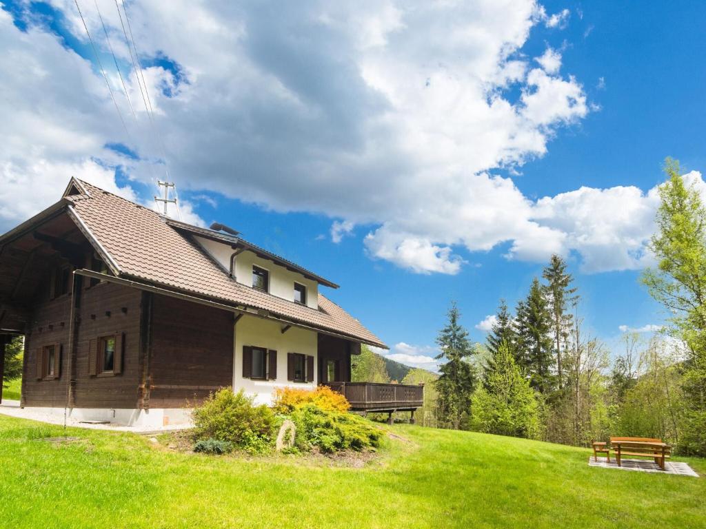 a house on a grassy hill with a bench at Chalet in Gnesau in Carinthia with sauna in Gnesau