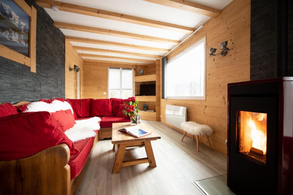 ein Wohnzimmer mit einem roten Sofa und einem Kamin in der Unterkunft le relais du tilleul in Chevenoz