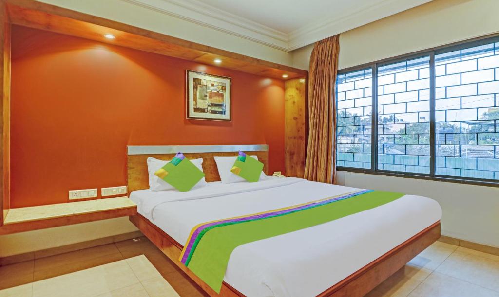 a bedroom with a large bed with a large window at Treebo Trend Suraksha Inn in Bangalore