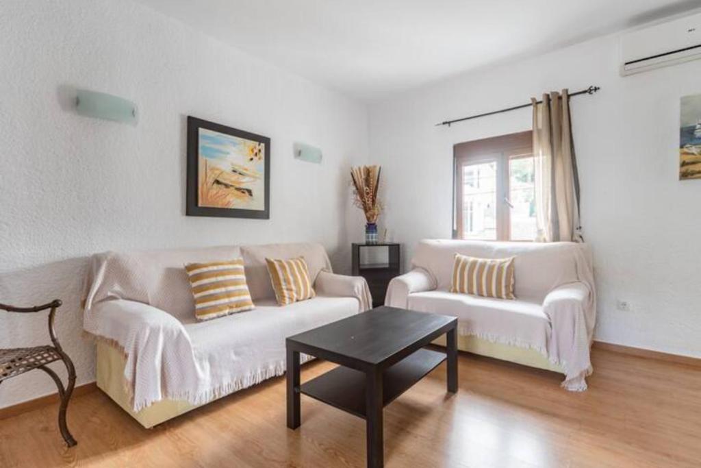 una sala de estar con 2 sofás blancos y una mesa. en Cala Blanca Javea/Residence, beach, pool, tenis A/C, en Jávea
