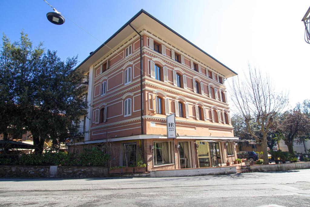 a large brown building sitting on the side of a street at Hotel PRime - Montecatini in Montecatini Terme