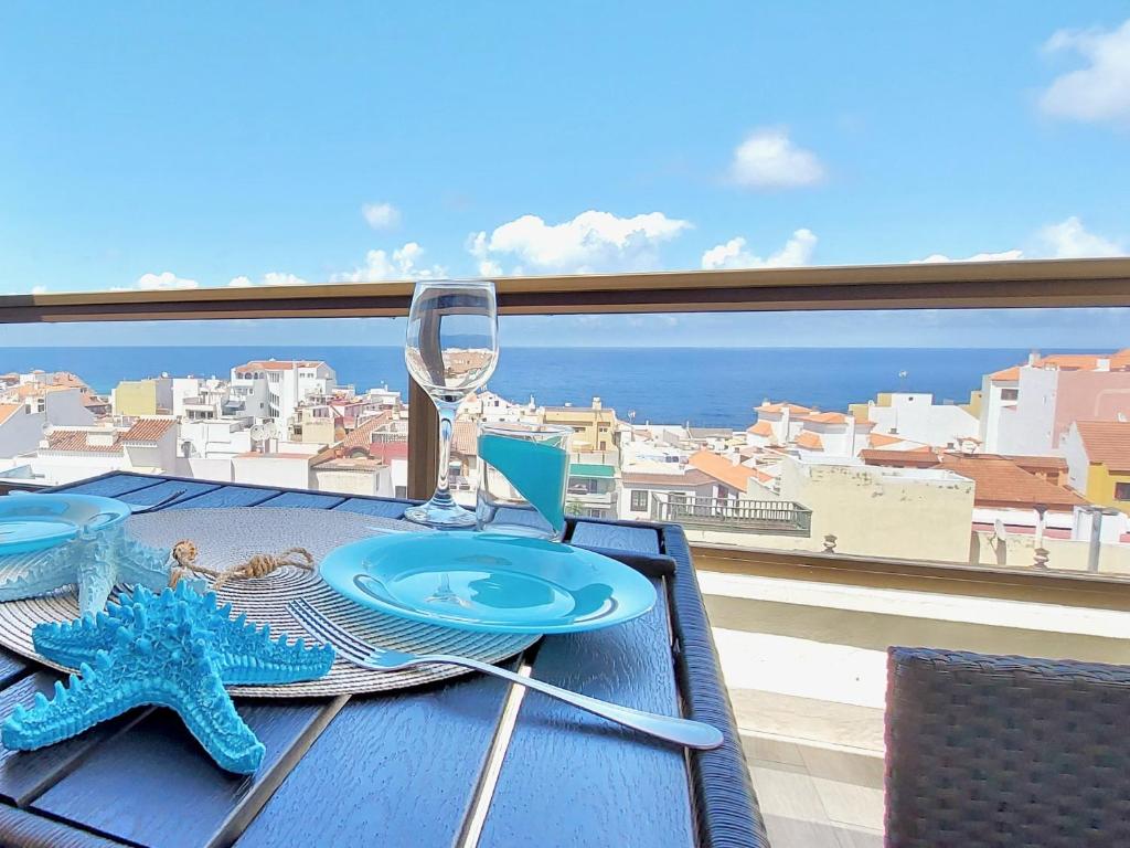een tafel met een glas wijn en een zeester op een balkon bij Ocean and Sky Studio Apartment in Puerto de la Cruz