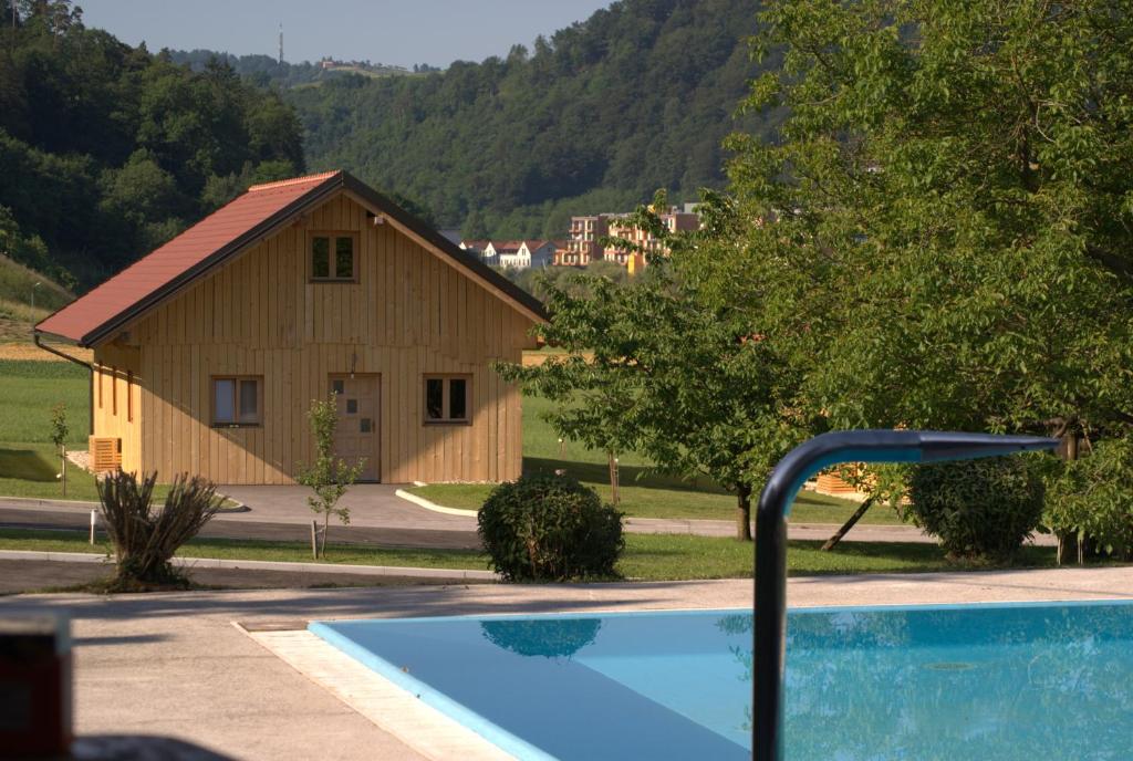 a house with a swimming pool in front of a building at Family Bungalow Glamping Laško in Laško