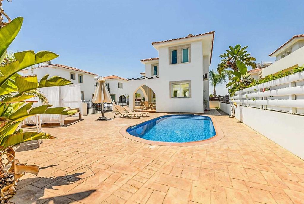 a backyard with a swimming pool and a house at Villa Constantina in Protaras