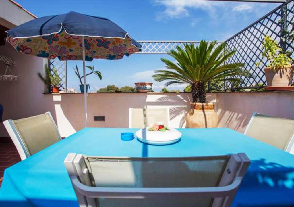 una mesa azul con un plato de comida y una sombrilla en Camera con Terrazza e Vista su Villa Malfitano, en Palermo
