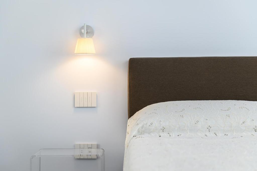 sypialnia z łóżkiem i 2 lampkami na ścianie w obiekcie Corso Umberto 58 w mieście Neapol