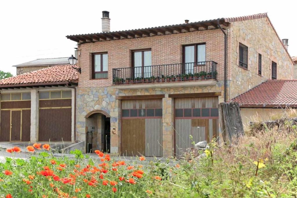 a large brick house with two garage doors at Casa Rural El Carrascal in Casarejos