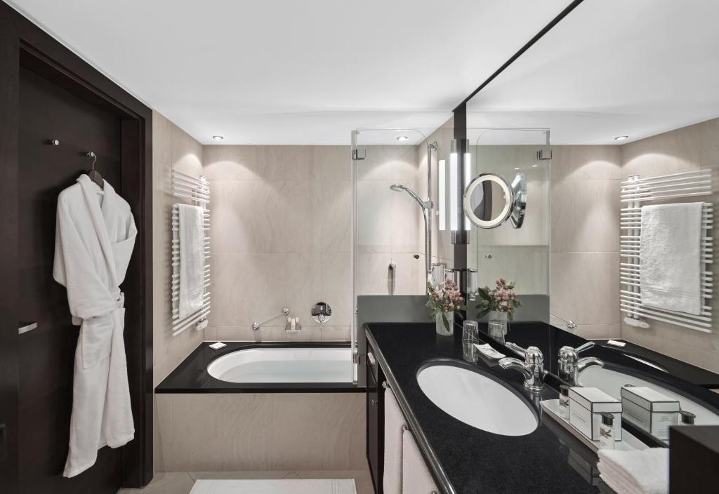 a bathroom with a large sink and a tub at Lebenberg Schlosshotel-Kitzbühel in Kitzbühel